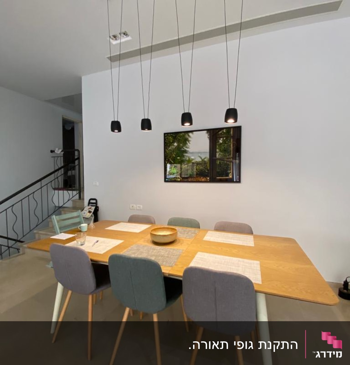 חמישה גופי תאורה תלויים מהתקרה בחדר אוכל